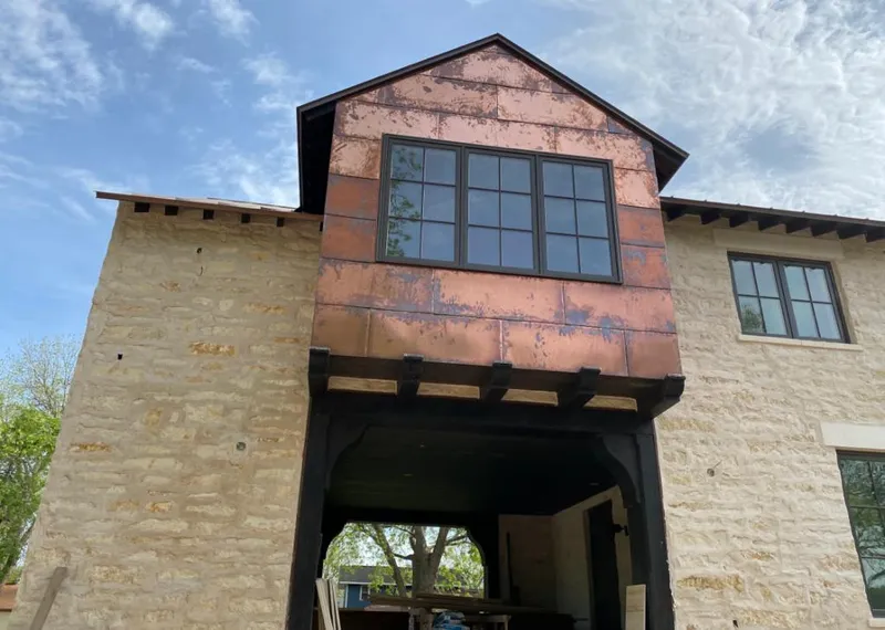 Copper metal panel facade on a stone building for Metal Roof Coating in Crowley